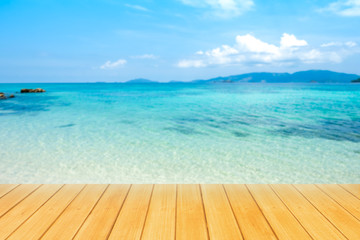 Empty wooden board table top with blurred beautiful blue or turquoise Ocean and beautiful blue sky background.