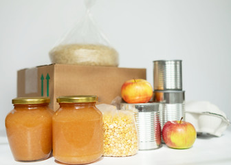 Coronavirus donation concept. Donation box with food isolated on white. Canned food, dried peas, rice, nuts. Top view.