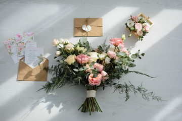 wedding decoration on a white background bouquet envelope invitations ray of light shadow patterns