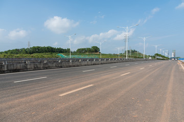 Low angle perspective landscape of asphalt highway covered with dirt lines