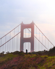 San Francisco Golden Gate Bridge, girl walking along the pathway at sunset during winter. 