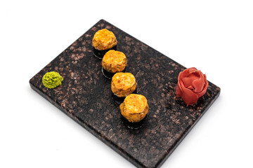 Hot sushi with wasabi and ginger in soy sauce on a white background
