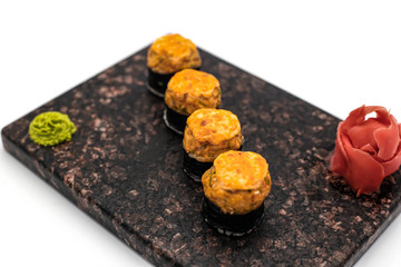Hot sushi with wasabi and ginger in soy sauce on a white background