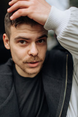 Obraz premium Portrait of a young man walking around the city. Brunette, beard. Cheerful, beautiful smile.