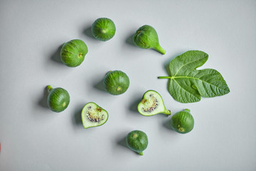 Green common fig with a leaf on grey background