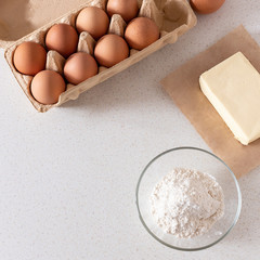 Baking ingredients: flour, eggs, butter on the table. Baking concept. 
Cooking flat lay with copy space. Top view. Mockup.