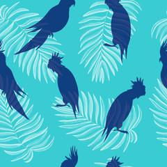 Parrots silhouettes seamless pattern on a blue background