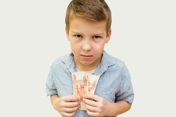 a schoolboy a boy of 10 years of Asian appearance holding in his hands banknotes of 5 thousand...