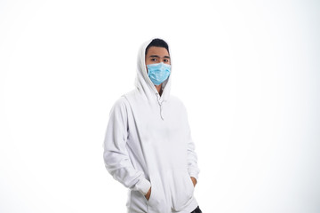 An Asian young man isolated on white background with casual entire and wearing a face mask. Hand gesture stop, sick, respect. during corona virus 