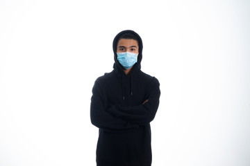 An Asian young man isolated on white background with casual entire and wearing a face mask. Hand gesture stop, sick, respect. during corona virus 