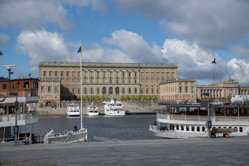 View over the old town district Gamla Stan from the island Skeppsholmen in a sunny spring morning with boats and harbor piers. 2