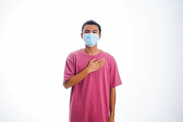 An Asian young man isolated on white background with casual entire and wearing a face mask. Hand gesture stop, sick, respect. during corona virus 