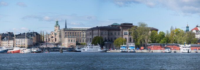 Fototapeta premium View over the Nybroviken bay with boats and old houses on the island Blasieholmen and the old town Gamla Stan in Stockholm,