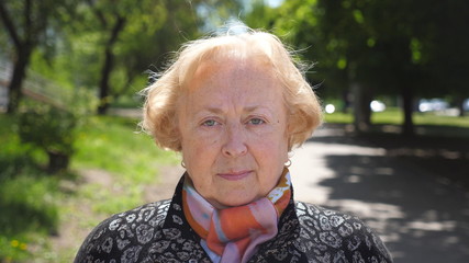 Portrait of beautiful elderly woman seriously and pensive looking at camera. Senior caucasian lady...