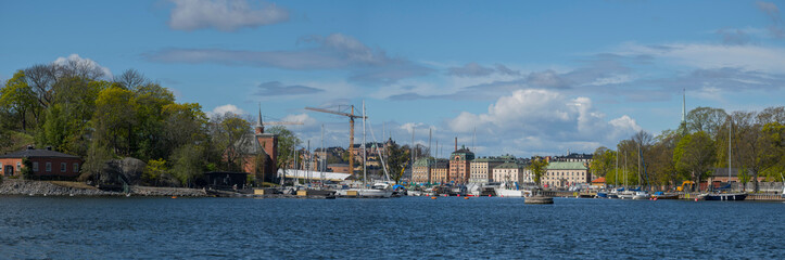 Fototapeta premium View over the Nybroviken bay with boats and old houses on the island Blasieholmen and the old town Gamla Stan in Stockholm