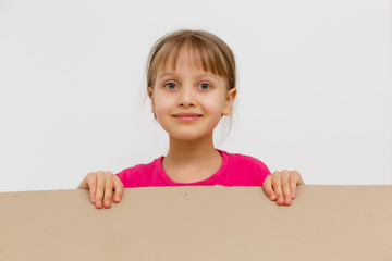 Cute little girl standing in large cardboard box, wanting to play hide-and-seek