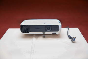 LCD Projector technology video presentation and home Entertainment object . mini led projector on wood table in a room projector home theater idea and concept . Close up projector in conference room .