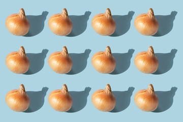 Onion pattern with shadow on a blue background. Agricultural Products.