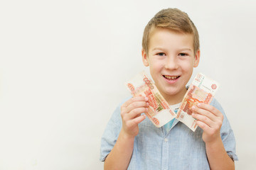 a schoolboy a boy of 10 years of Asian appearance holding in his hands banknotes of 5 thousand...