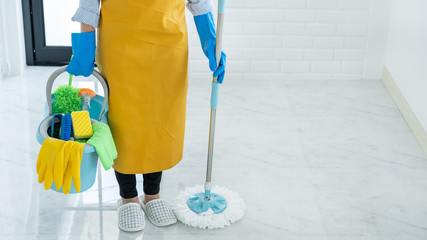 Woman housekeeper with mop and bucket with cleaning agents for cleaning floor at home, Floor care and cleaning services.