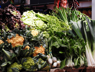 Fresh green raw vegetables and herbs on display in farmers market. Barcelona, Spain