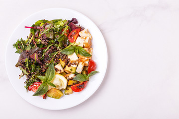 quinoa salad with tofu, broccoli, avocado, olives, tomato and spinach.