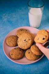 Homemade chocolate cookies on pink plate and blue background.