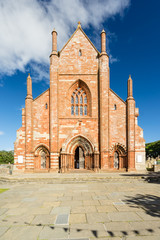 front view of St Magnus Cathedral on a sunny day in Kirkwall, Orkney Islands, Scotland. The holy red sandstone architecture is part of the church of Scotland