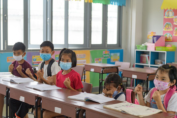 school kids with protection face mask against flu virus at lesson in classroom