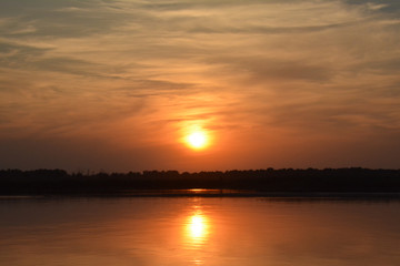 Fototapeta na wymiar Beautiful sunset on the Volga river. The sun is reflected in the river. Russia. Golden background.