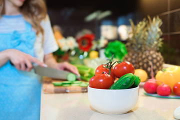 Young Woman Cooking in the kitchen. Healthy Food - Vegetable Salad. Diet. Dieting Concept. Healthy Lifestyle. Cooking At Home. Prepare Food