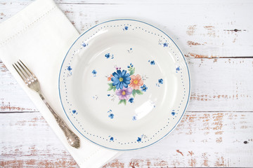 Empty white plate on rustic wooden table. Decorative ceramic plates, traditional floral pattern. Top view. - Powered by Adobe