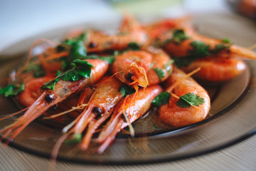 Delicious prawns with coriander in a plate on the table. Fresh seafood dish close-up