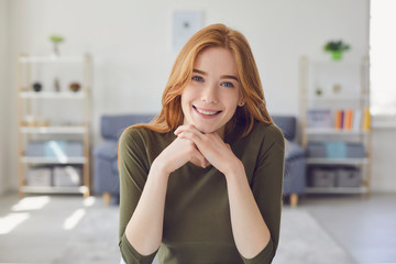 Online video call. Headshot of a happy girl looking at the camera smiling listening to friends...