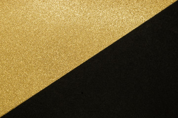 Abstract background of golden shiny and black craft paper split in the half make triangle shape
