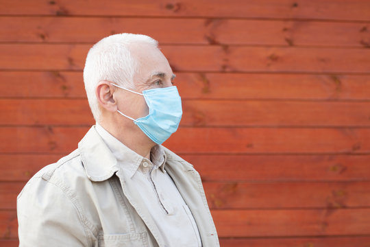 Senior man in protective face mask respirator, outbreak of viral disease coronavirus covid-2019