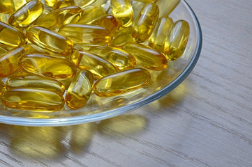 Fish oil capsules on a glass plate. A lot of vitamin omega 3. Close-up.