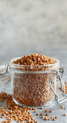Raw dry buckwheat grain  in a jar with a spoon