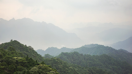 Beautiful glorious colourful sunrise in the national park over the mountains in China, mysterious landscape with hills, clouds, mist and colour shades, trekking and hiking outdoors, peak summit
