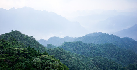 Beautiful glorious colourful sunrise in the national park over the mountains in China, mysterious landscape with hills, clouds, mist and colour shades, trekking and hiking outdoors, peak summit
