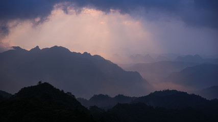 Beautiful glorious colourful sunrise in the national park over the mountains in China, mysterious landscape with hills, clouds, mist and colour shades, trekking and hiking outdoors, peak summit
