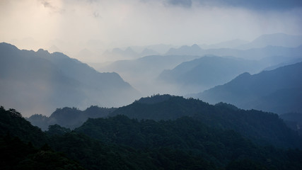 Beautiful glorious colourful sunrise in the national park over the mountains in China, mysterious landscape with hills, clouds, mist and colour shades, trekking and hiking outdoors, peak summit
