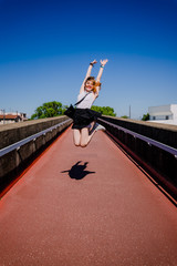 Jeune fille  sautant sur une passerelle