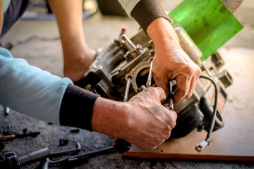 Repairman disassembled motorcycle engine in the shop