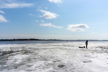 Fototapeta na wymiar natural winter background, a fisherman on the ice. fishing in the winter, the place for copyspace