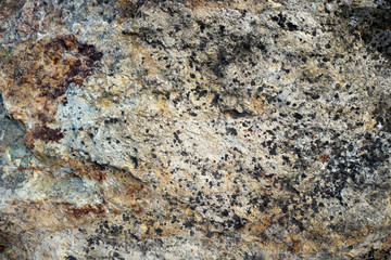 rough light surface of natural rock from a wall with abstract colors - background texture of a stone