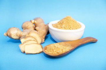 Picture of ginger root and ginger powder on a blue background