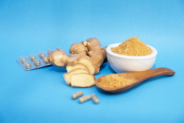 Picture of ginger root and ginger powder on a blue background