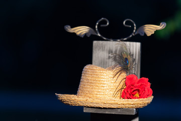 Straw hat standing on a wooden panel with a red rose