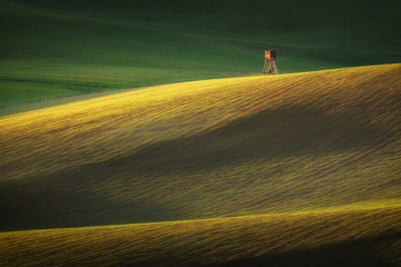 Spring landscape with hunting hide. Fields and meadows in Turiec region, Slovakia. Wavy country...